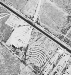 Approx. 1 1/2 miles northwest of town along Hwy 385, the drive-in has been closed since the late '70s but the screentower and snackbar still stand (in fact, you can see them in this photo). Curious thing though, see the lot with the arched ramps to the so