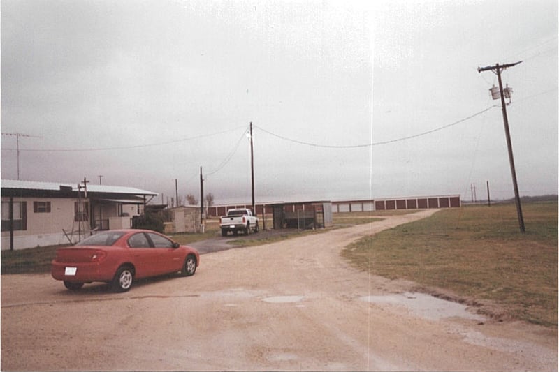 entrance, the ticket booth was located next to the white pickup truck where the fence in enclosure is