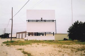 This is the entrance driveway. The marquee was gone. The ticket booth is behind the trees. The screen is just barely visible to the right of the billboard. The auto repair building is shown.