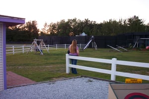 A vigilant mother watches over her kids on the playground equipment.