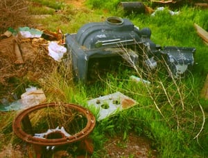 Junk behind theater lot.  The item to the lower left looks like a huge version of the intermittent device used for advancing and holding frames of film in projector, but it is too large for that purpose.