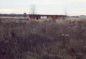 Overgrown field with projection/concession building