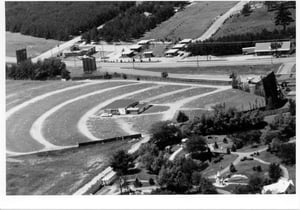 aerial photo of field, building, and screen tower