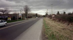 Fraser Hwy. There will be a right hand turn lane and a center turn lane for people coming from Vancouver. The red & white sign on the right marks the entrance.