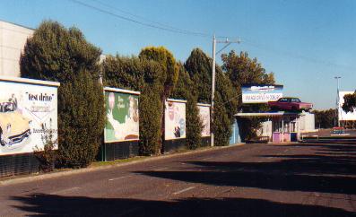 Vintage signs line the driveway as patrons approach the famous Dodge Pheonix atop the ticket box. Anna Joske Photo 2001