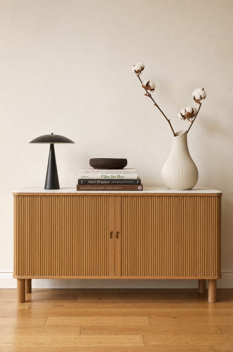 Sideboard mit Vase, Lampe und Designbüchern