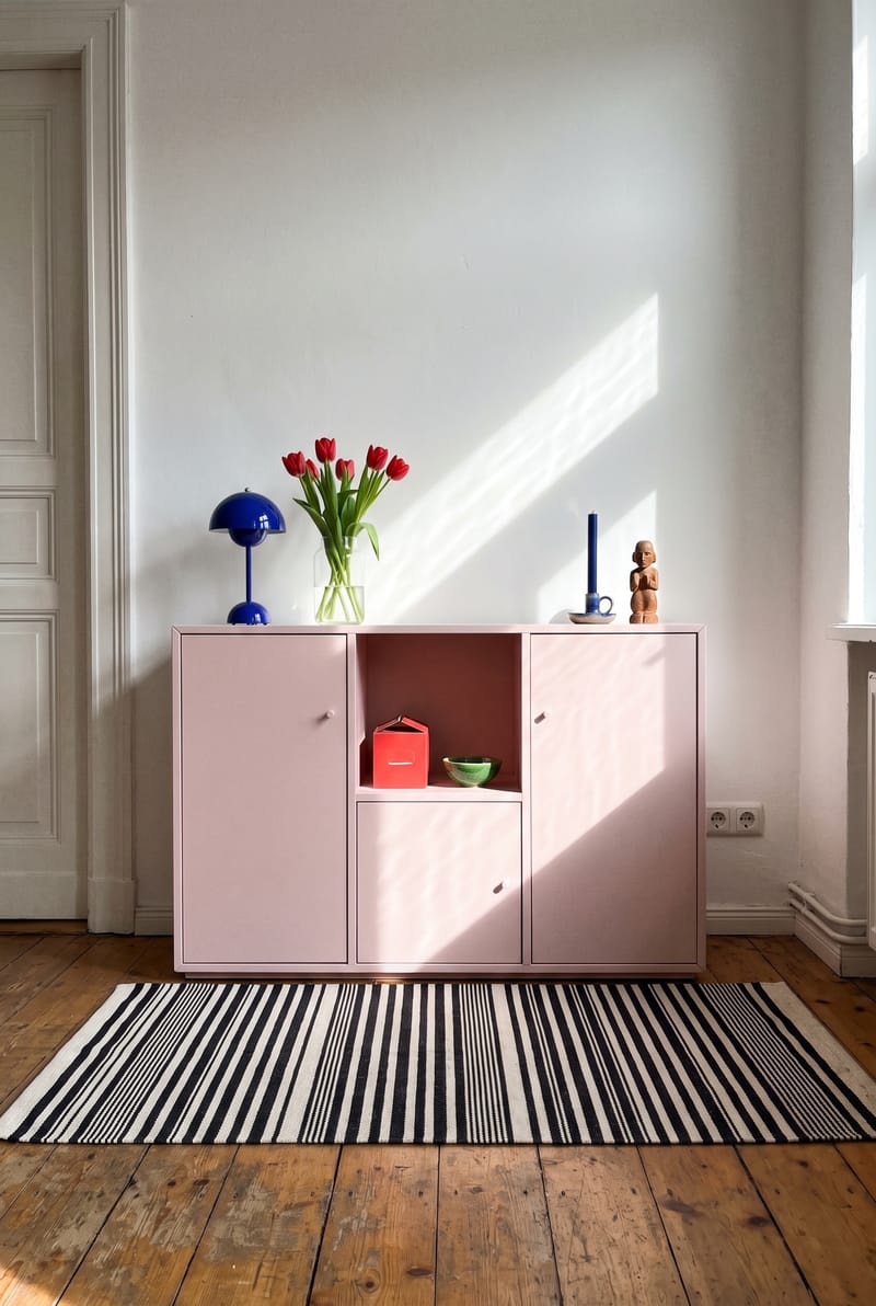 Sideboard Deko Idee im Dopamin Stil: kobaltblaue Pilzlampe, rote Tulpen im Glas und Streifenteppich an rosa Modulkommode im Altbau