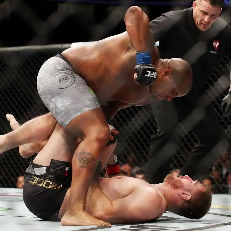 Daniel Cormier standing over an unconscious Stipe Miocic at UFC 226. Credits to: Christian Petersen - Zuffa LLC.