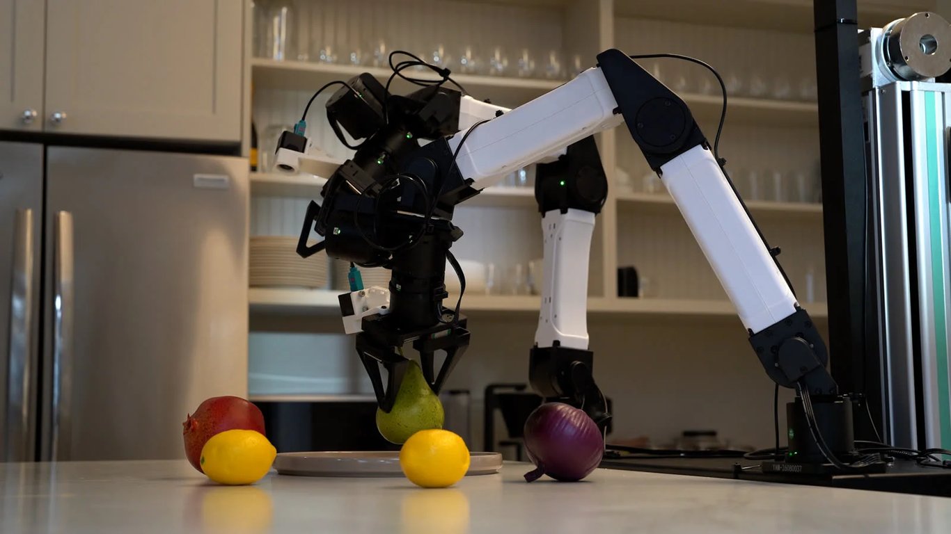 Robot arm manipulating fruit on a kitchen countertop