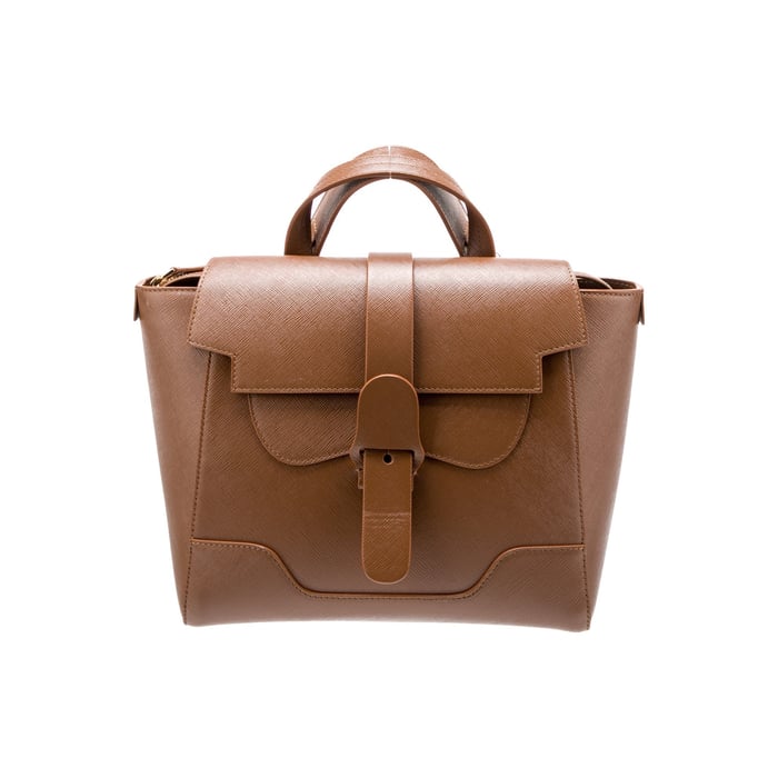 Senreve Maestra in cognac textured Saffiano-style leather, showing the cross-hatch grain against the smooth flap edges
