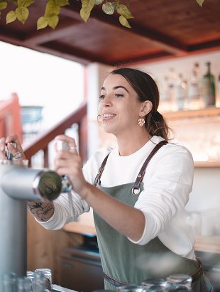 Bartender with a shaker beneath the pergola of a Ginto bar