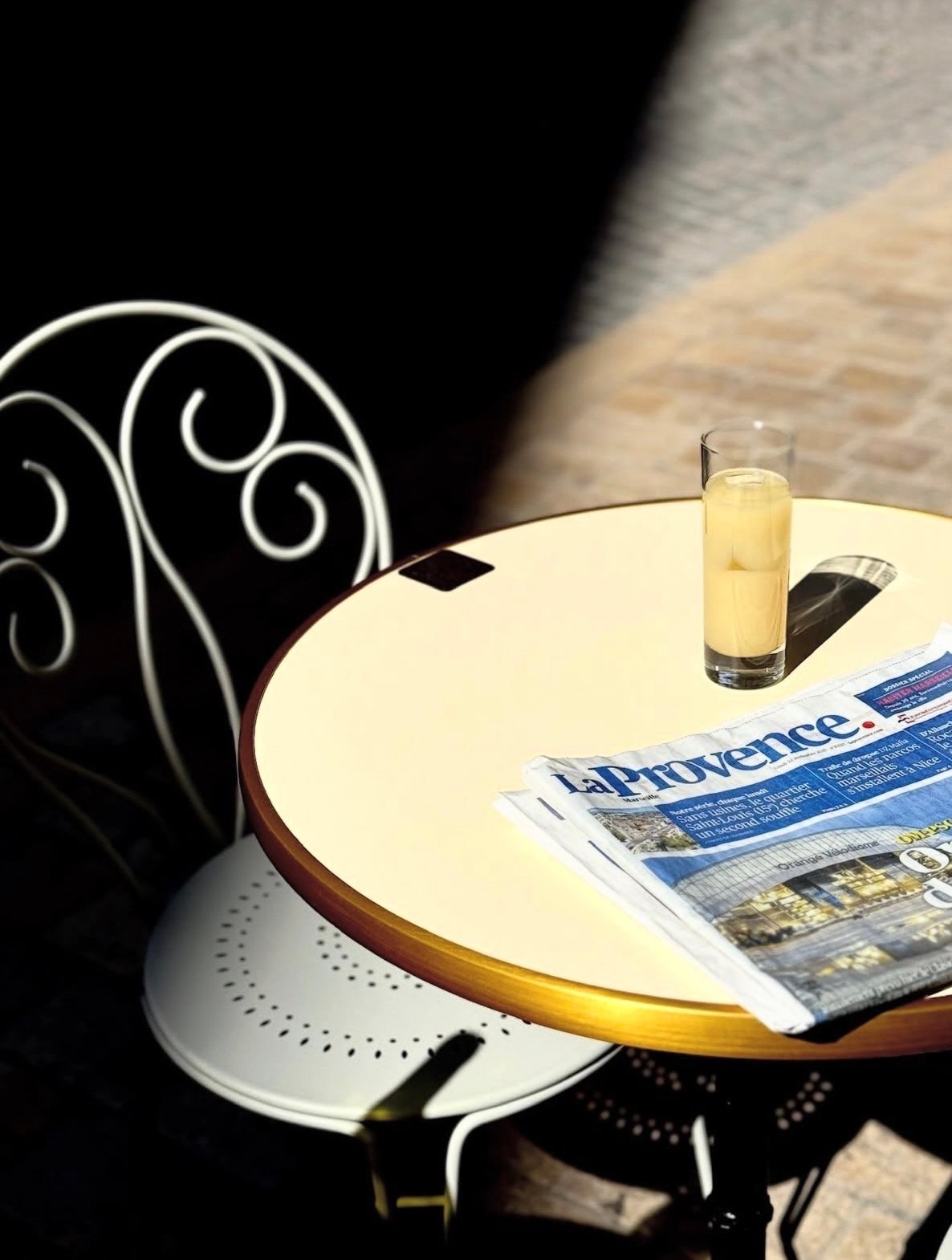 Round table with ornamental chair, fresh lemon water, and newspaper—a quiet corner of the hotel's relaxation space.