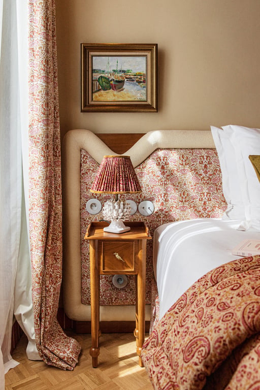 Chambre aux tissus fleuris et tête de lit capitonnée