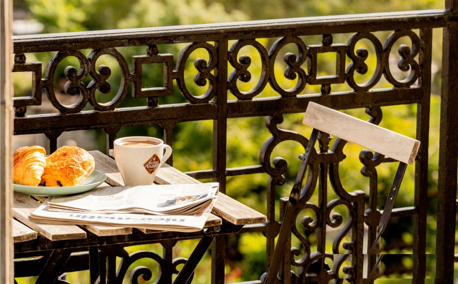 Petit-déjeuner au balcon en fer forgé de la maison Aria à Nice, café et viennoiseries