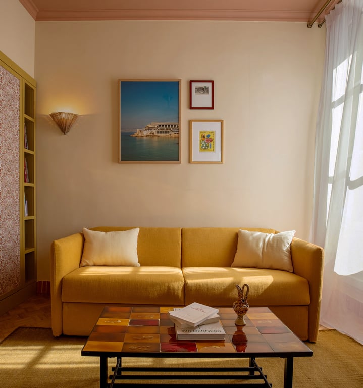 Amista, Marseille: living area with a yellow sofa and framed pictures