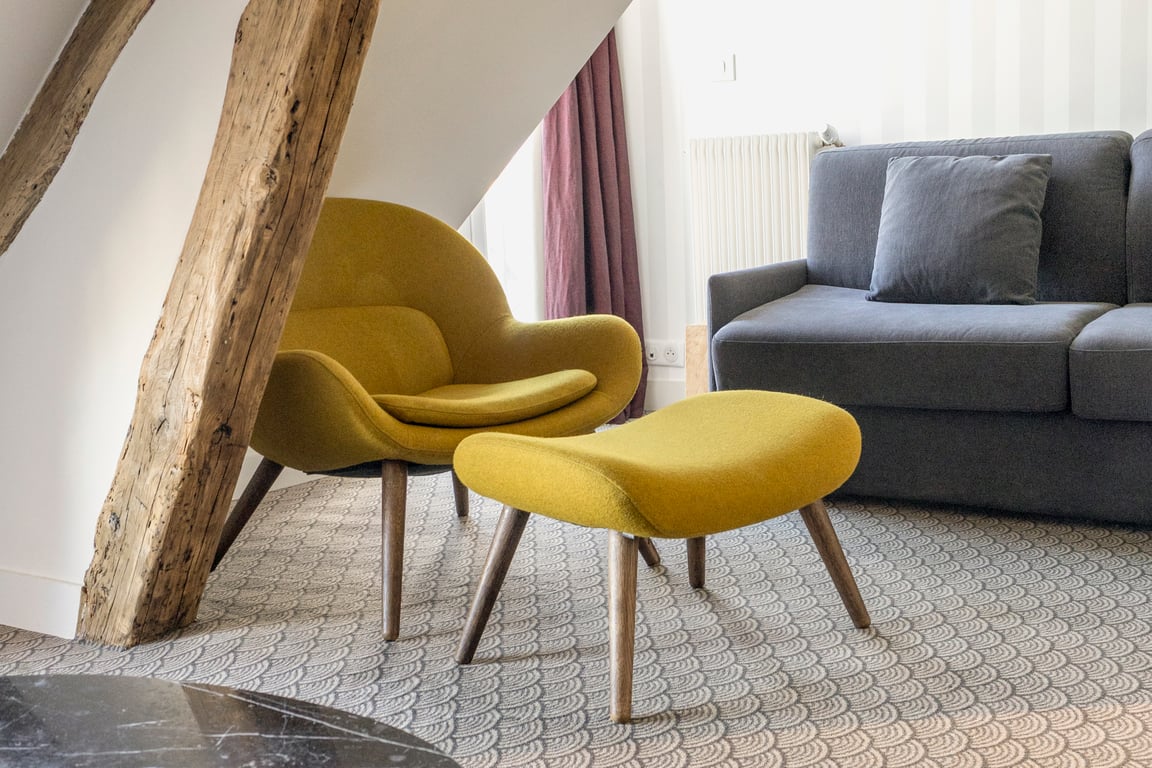 Paradis, Paris: attic bedroom with a yellow armchair