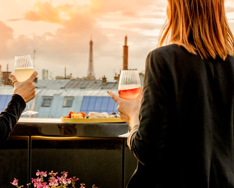 Pilgrim, Paris: glasses raised facing the Eiffel Tower at sunset