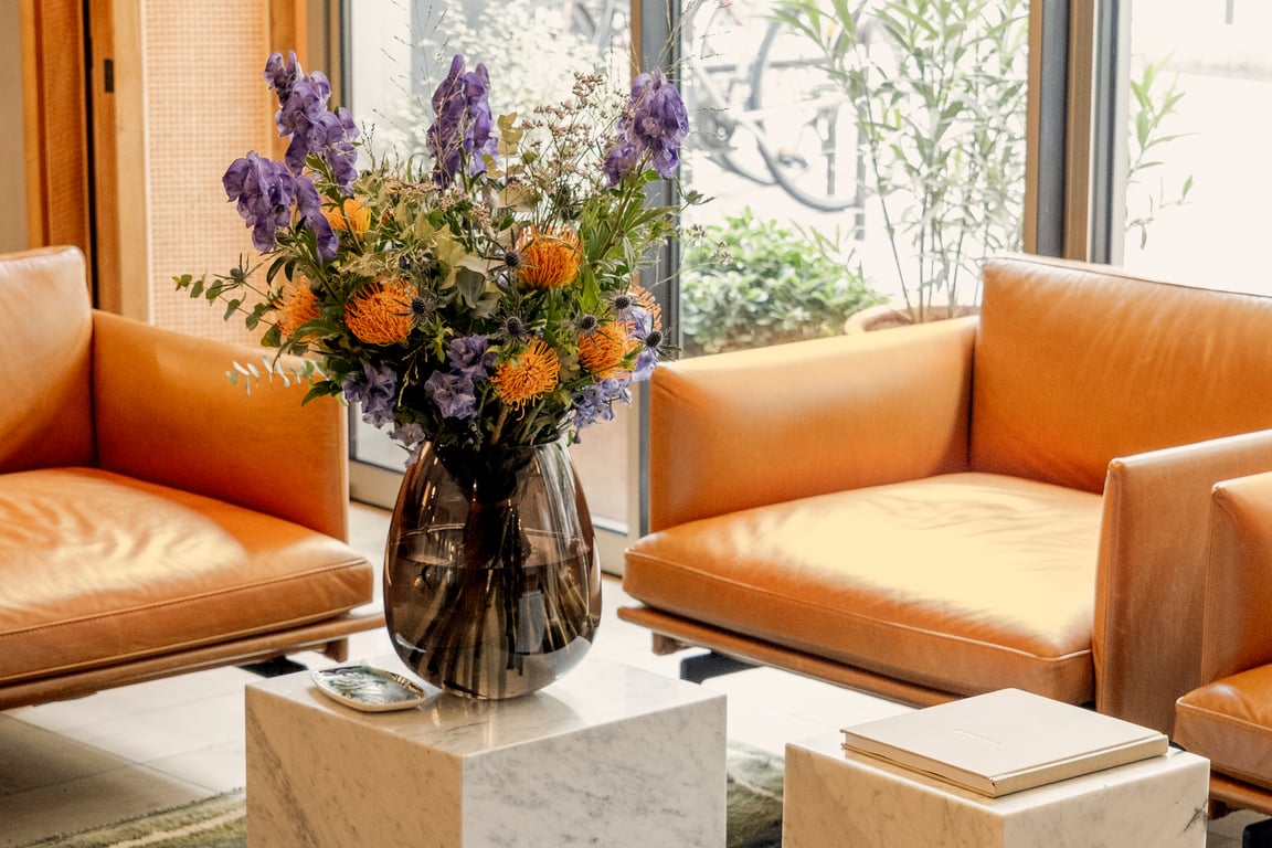 Pilgrim, Paris: tan leather lounge with a bouquet of flowers