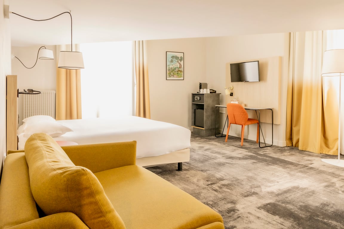 Vendôme, Nice: bedroom with a yellow sofa and desk