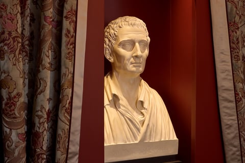 Buste de Montesquieu dans le salon de l'hôtel, encadré de rideaux à motifs floraux