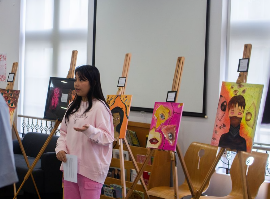 A student presents her artwork during an in-school art showcase.