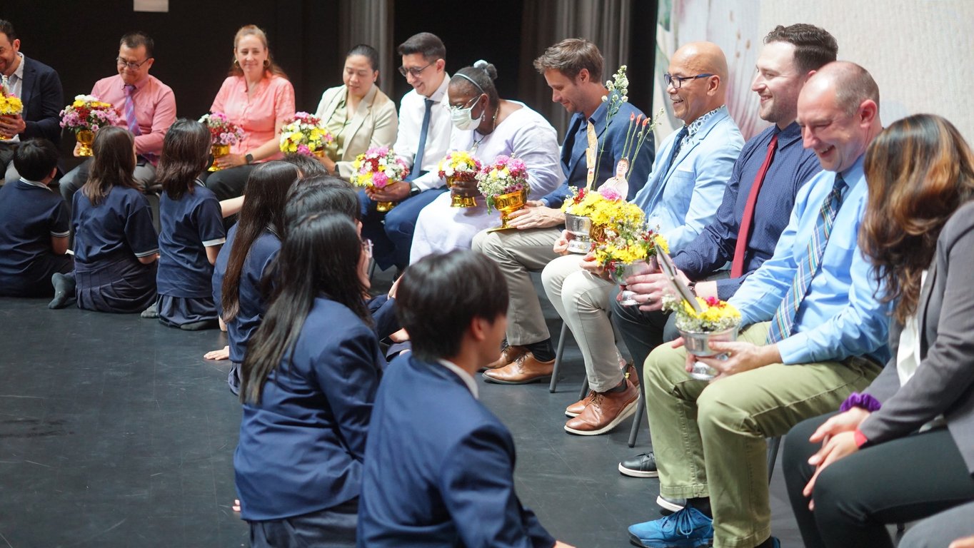 Secondary students presenting flowers to teachers during the Wai Kru Ceremony.