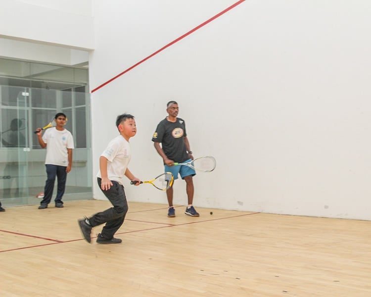 Squash session in progress at the indoor court of the school.