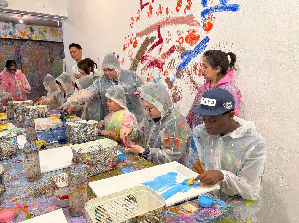 “Students taking part in a splash painting activity.
