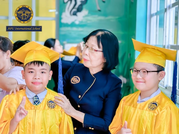 Elementary students celebrating their graduation with a teacher.