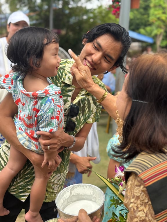 Families engaging in Thai traditions during the Songkran festival.