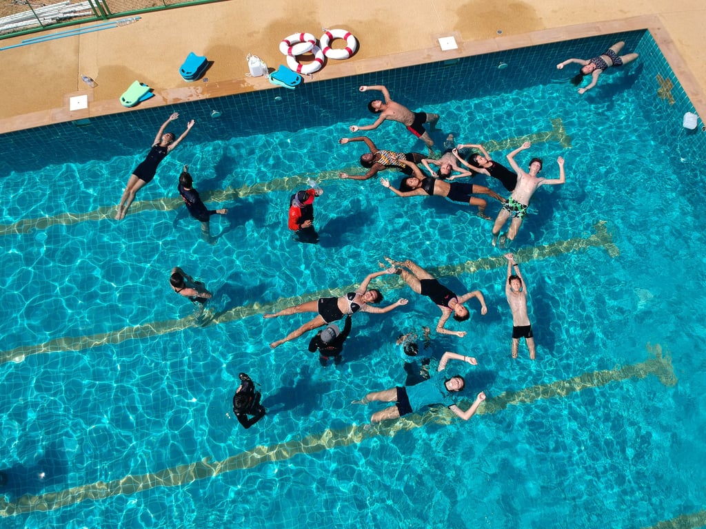 Students practicing floating techniques during a swimming session.
