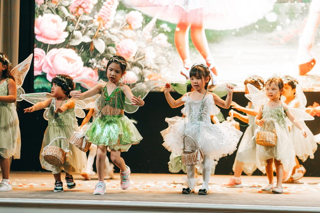 Children performing on stage during graduation concert.