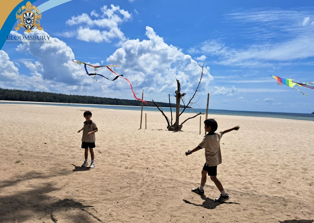 Year 3 students flying kites on the beach.