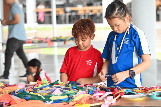 Primary students working together on a ribbon art project.