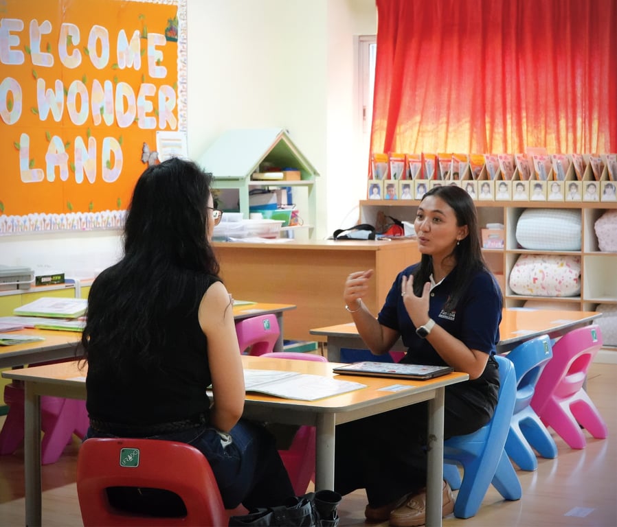 School counselor meets with a parent during a PTM.