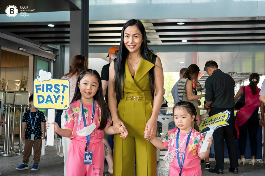 Students arrive for their first day, supported by family and teachers.