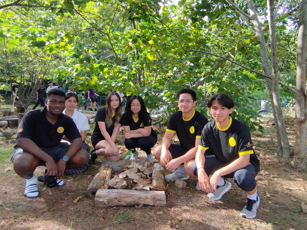Upper Years students participating in an Outdoor Education activity on the school’s Eco Hill, fostering teamwork and environmental awareness.