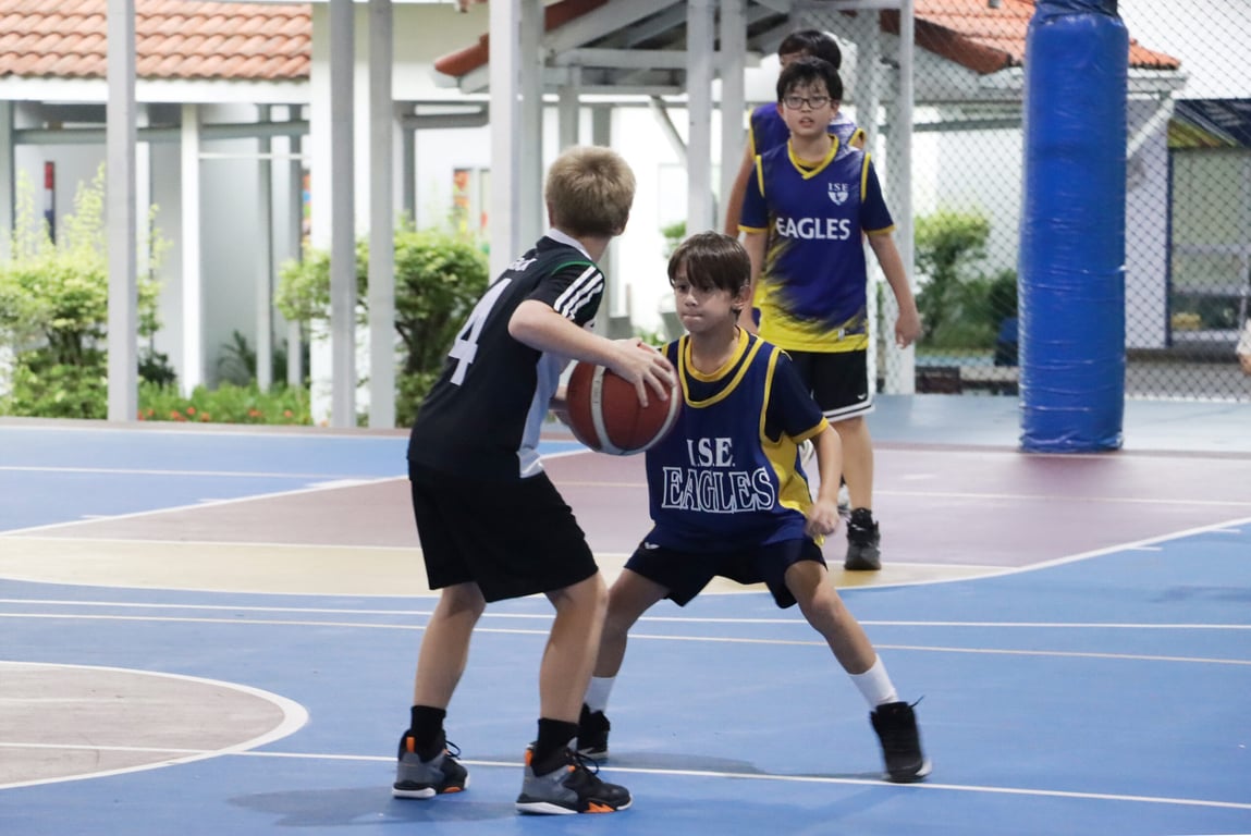 ISE Eagles player guarding during a school basketball match.
