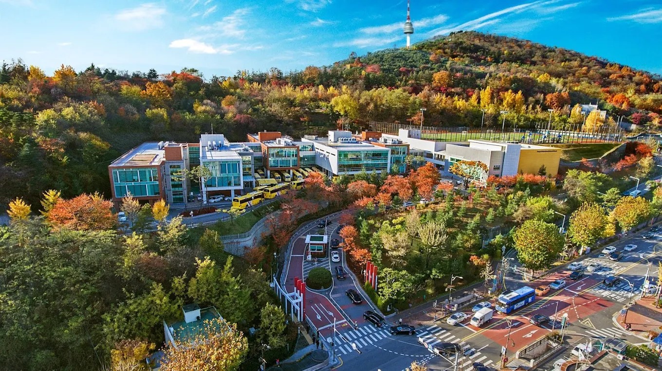 Aerial view of YISS campus surrounded by autumn foliage.