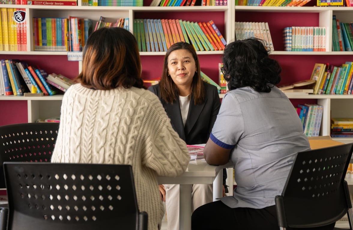A teacher discussing a child's progress with their parents at the PTM.
