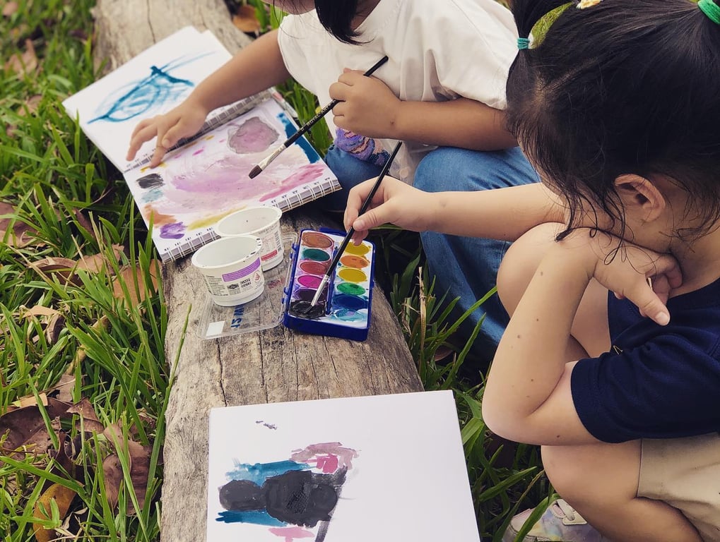 Students taking part in a creative activity while on their outdoor trip with the 'Forest School' program