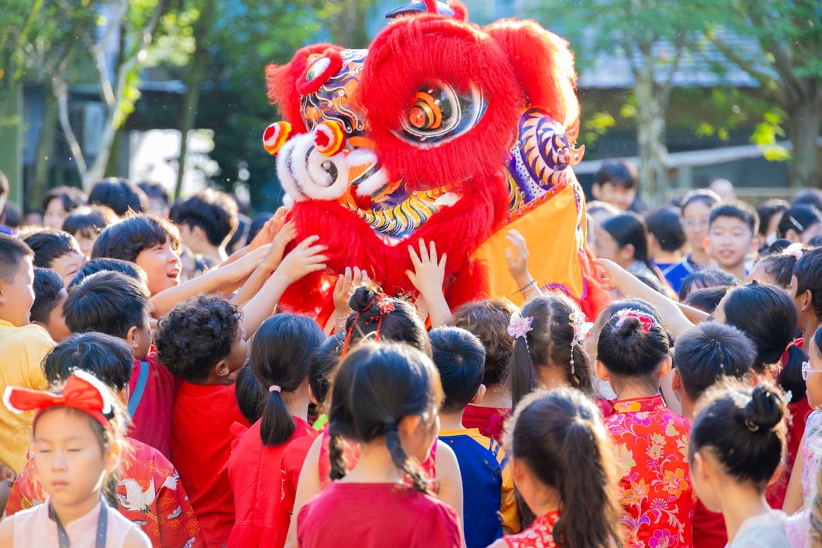 Primary Students gather around the lion dance during Chinese New Year celebrations.