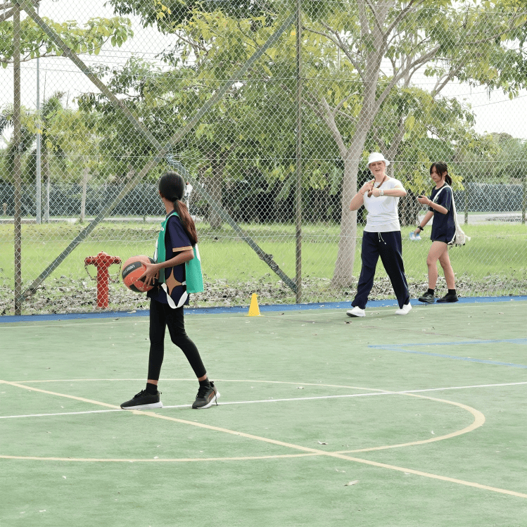 Students enjoy a friendly basketball session during Physical Education under the morning sun.