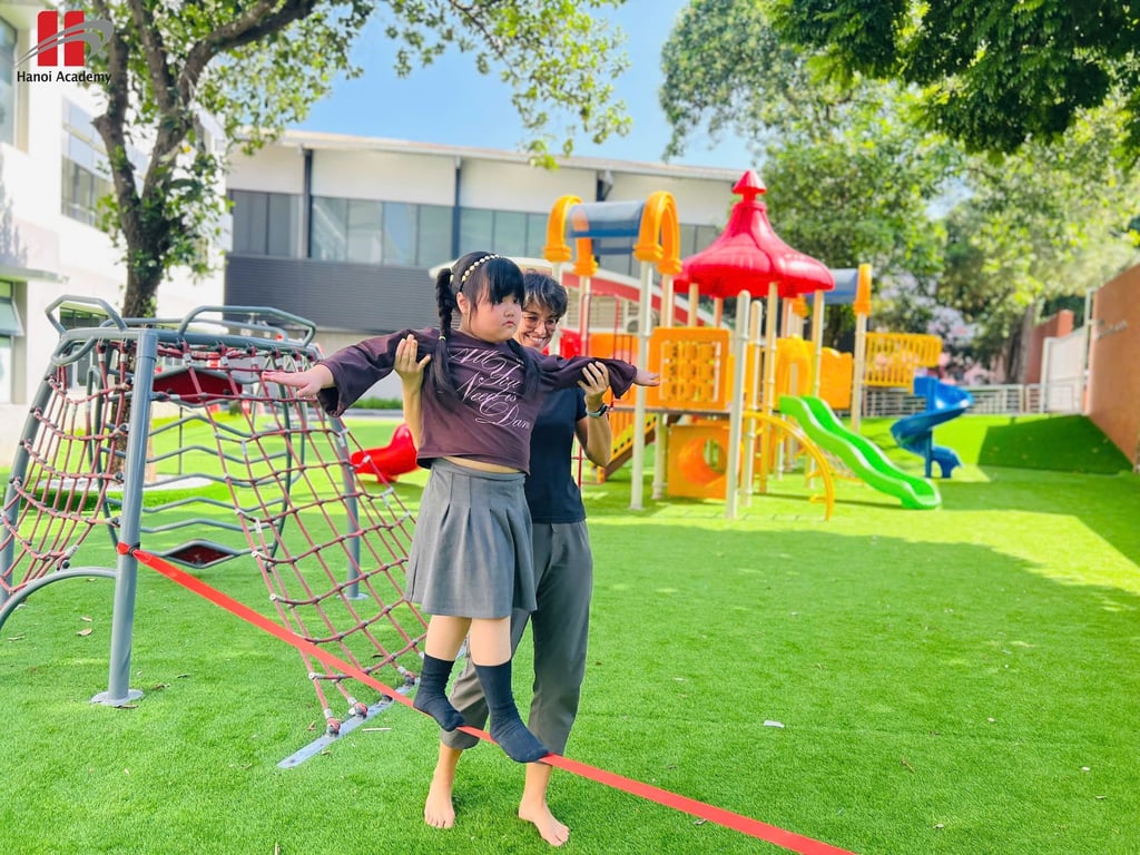 Student practicing balance outdoors with teacher support on the playground.