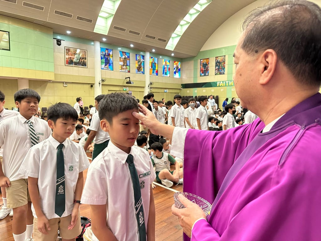 Students attend the Ash Wednesday Mass service at the school
