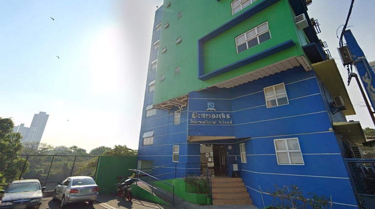 The vibrant blue and green facade of the Britesparks International School building.