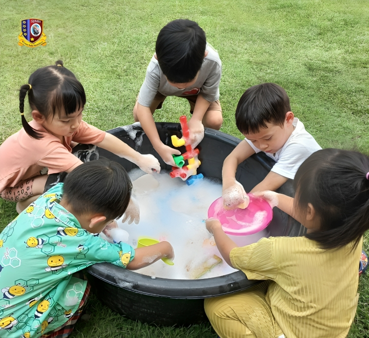 Kindergarten students washing toys together during class activity.