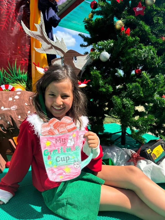 Student holding a decorated cup during a Christmas activity.