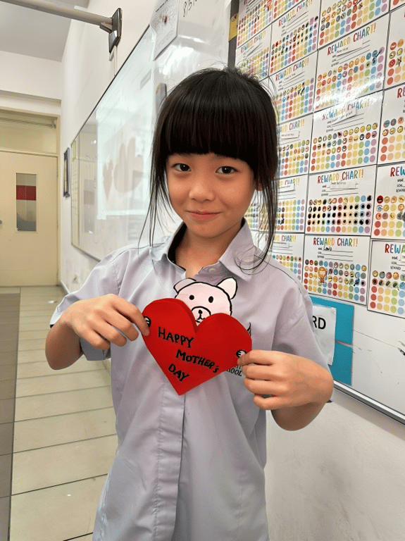 Student shows off a handmade card created in class for Mother's Day!