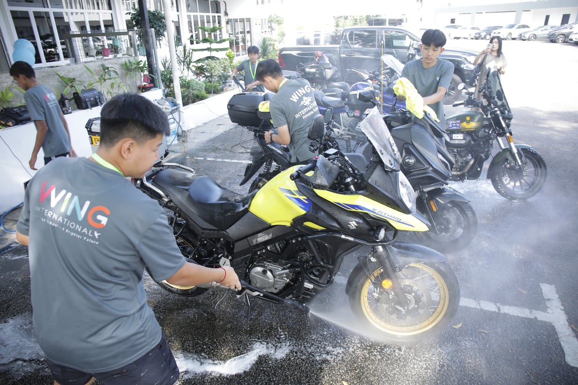 Students washing motorcycles as part of a school fundraising event.